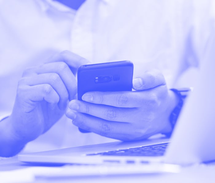 close up focus man hand hold mobile for work or play or check alert notification on smart phone devi...