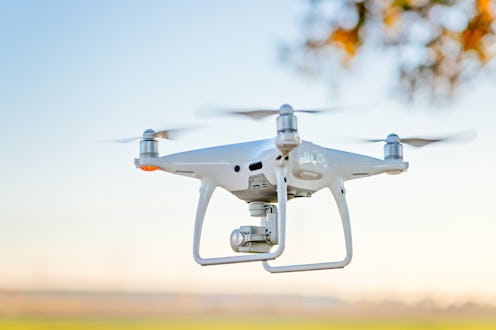 Professional drone with camera in flight. White drone