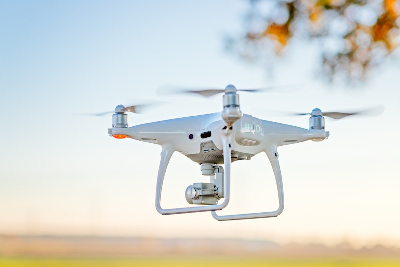 Professional drone with camera in flight. White drone 