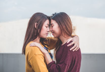 Asia lesbian LGBT Couple hug and nose kiss on rooftop of building with happiness moment