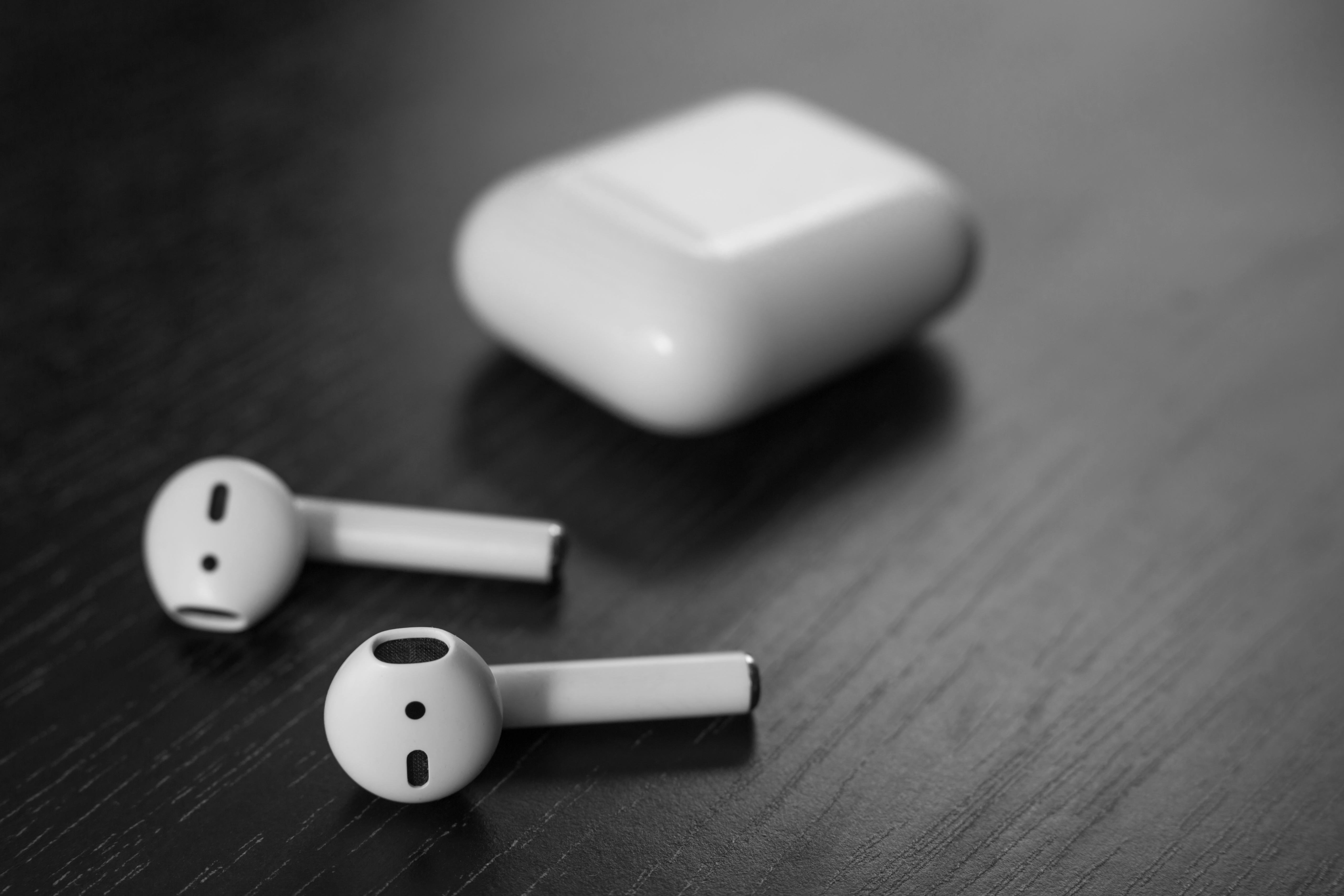 Air Pods. with Wireless Charging Case. New Airpods 2019 on black background. Airpods. Copy space .Ea...