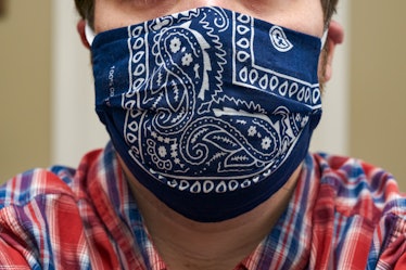 A close up photo of how one wears a homemade, cloth face mask covering the mouth and nose. This mask...