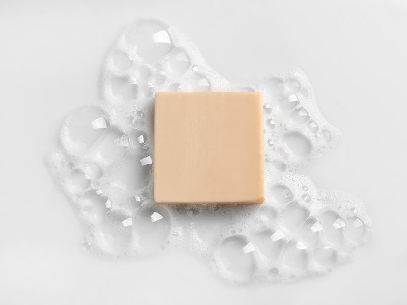 Soap bar and foam on white background, top view. Mockup for design