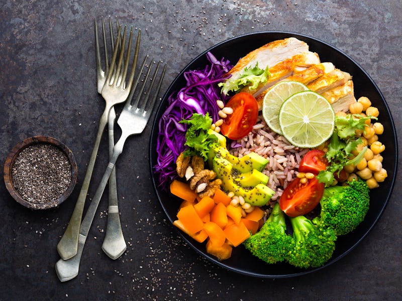 Buddha bowl dish with chicken fillet, brown rice, avocado, pepper, tomato, broccoli, red cabbage, ch...