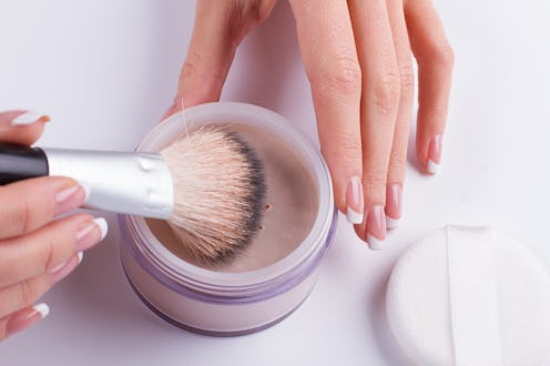 Beautiful french manicure. Women's hands holding the powder and brush.