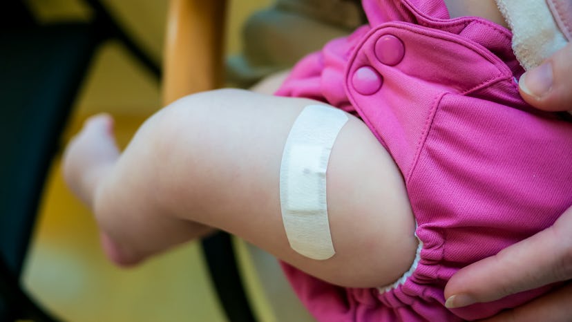 Band-aid on baby after shot in leg.