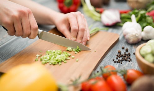 Chef cuts the vegetables into a meal. Preparing dishes. A woman uses a knife and cooks.