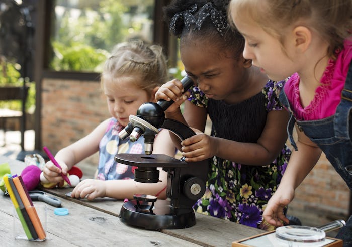 Little Girls Using Microscope Learning Science Class