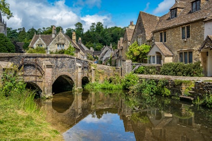 Blue skies and reflections in the picturesque Cotswold village of Castle Combe.