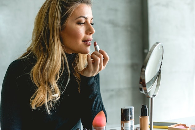 Beautiful woman Putting lipstick