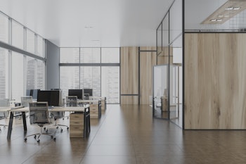 Interior of stylish open space office with gray and wooden walls, tiled floor, panoramic windows wit...