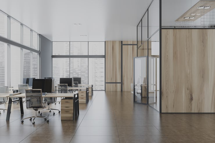 Interior of stylish open space office with gray and wooden walls, tiled floor, panoramic windows wit...