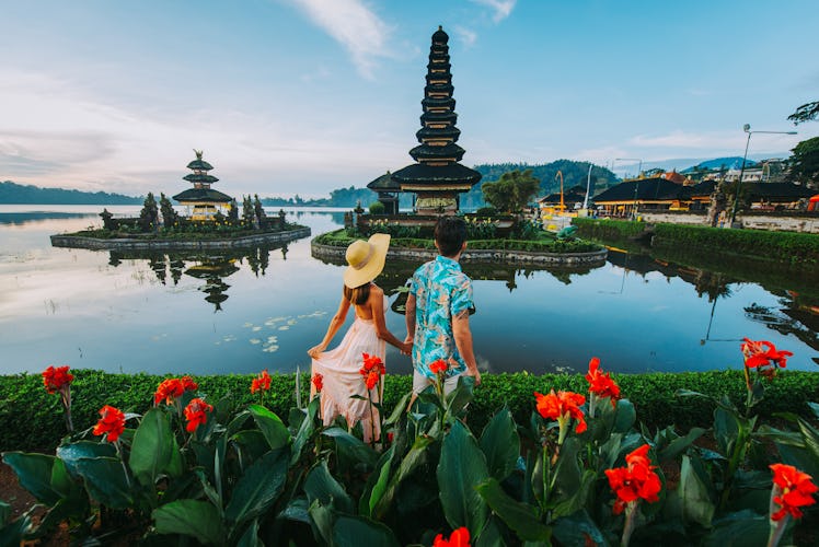 Couple spending time at the ulun datu bratan temple in Bali. Concept about exotic lifestyle wanderlu...