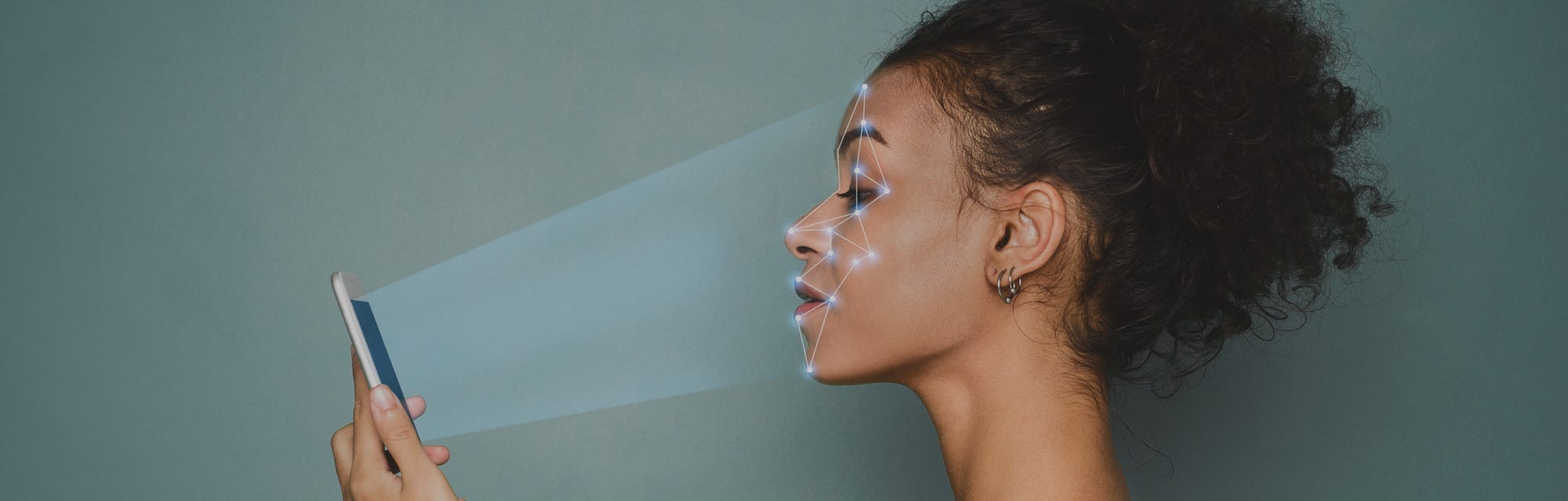 Biometric identification. African-american woman scanning face with facial recognition system on sma...