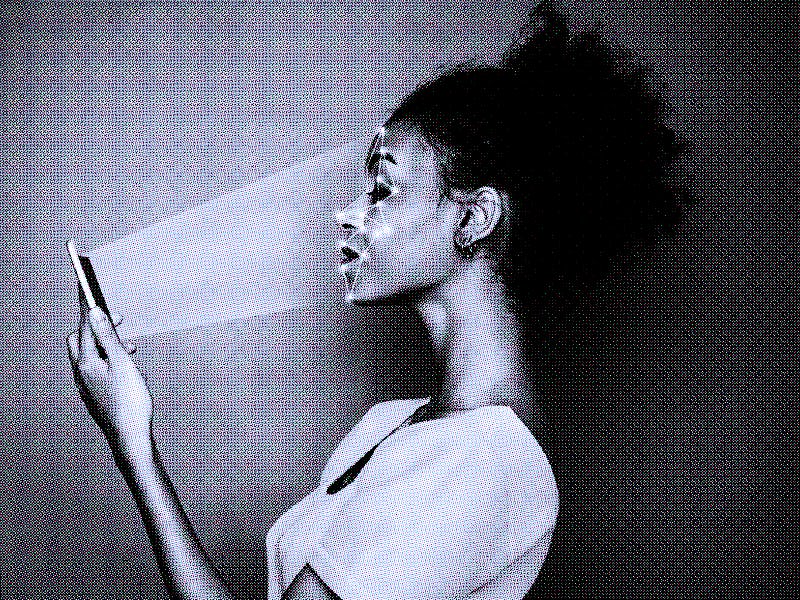 Woman scanning face with facial recognition system on smartphone, with rays coming out of the phone ...