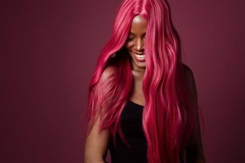 mixed race black woman with pink hair happy smiling. creative hair colour 