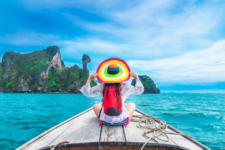 Summer lifestyle traveler woman in bikini and big hat joy relaxing on boat, Kai island, Andaman sea,...