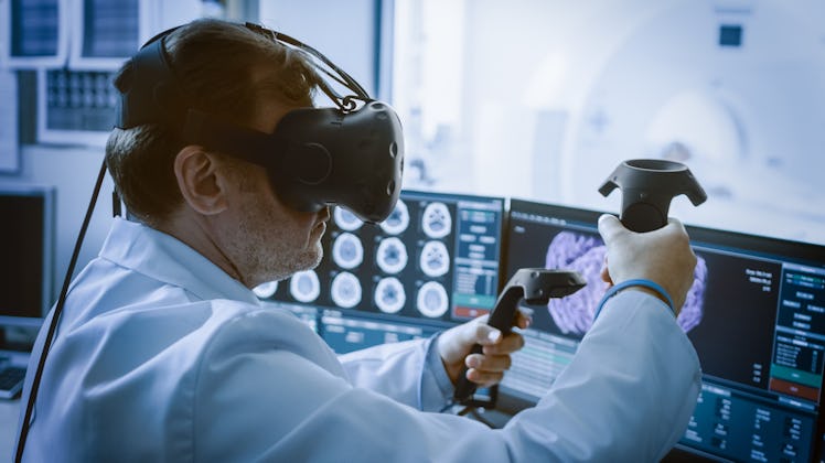 Futuristic Concept: In Medical Laboratory Surgeon Wearing Virtual Reality Headset Uses Controllers t...