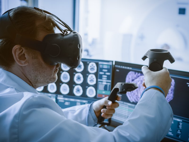Futuristic Concept: In Medical Laboratory Surgeon Wearing Virtual Reality Headset Uses Controllers t...
