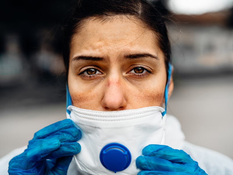 Exhausted doctor/nurse wearing coronavirus protective gear N95 mask uniform.Coronavirus Covid-19 out...