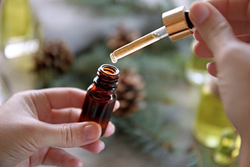 Woman filling in bottle with pine essential oil