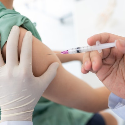 Close up of a Doctor making a vaccination in the shoulder of patient.