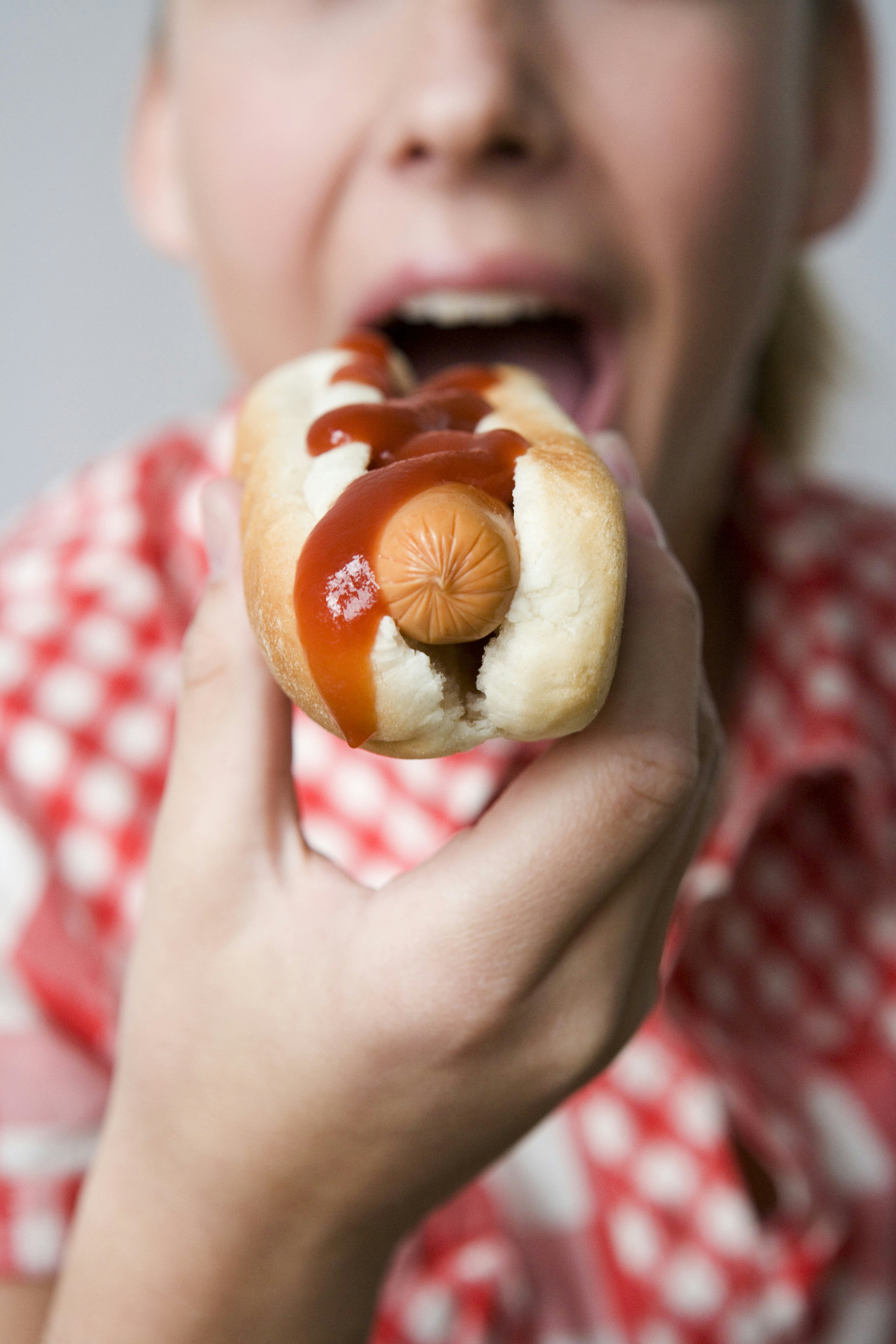 Close-up of teenage girl eating hotdog