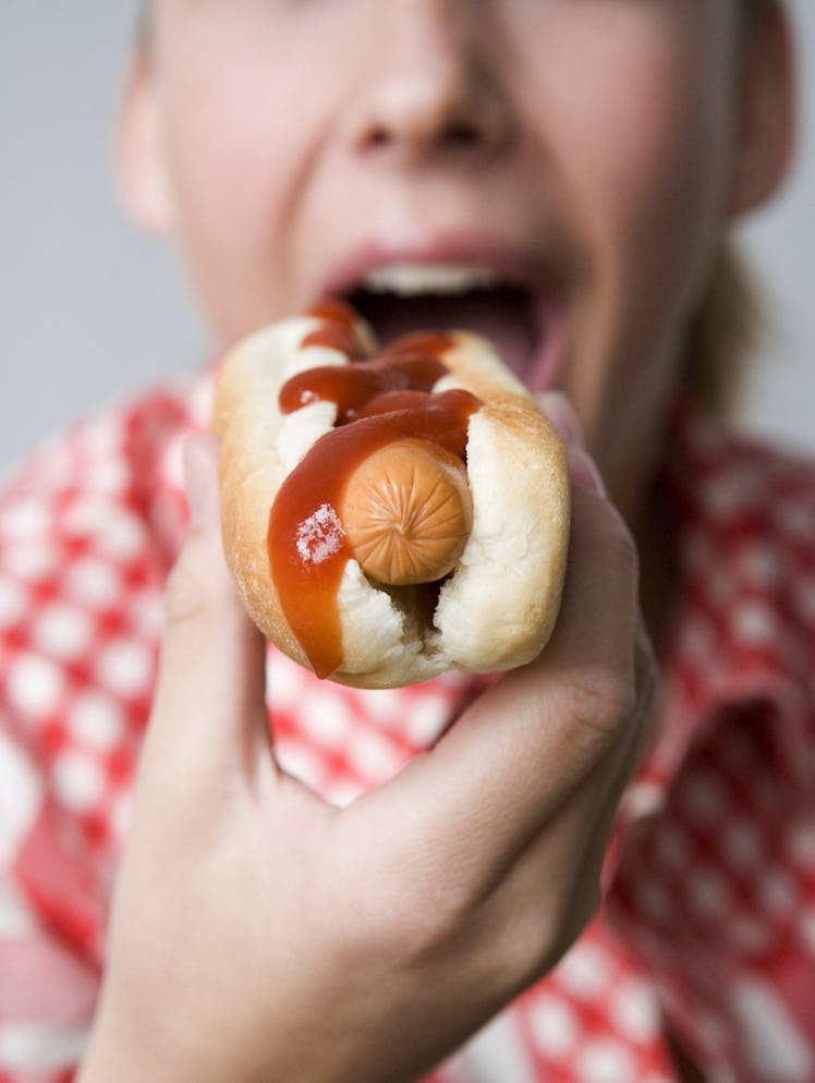 Close-up of teenage girl eating hotdog