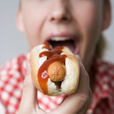 Close-up of teenage girl eating hotdog