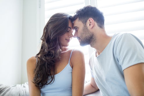 Young couple romancing in bedroom at home