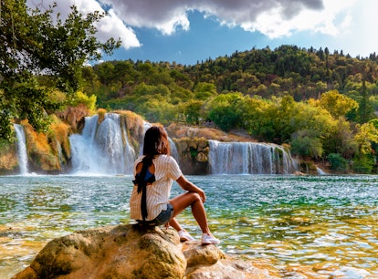 A woman admires waterfalls, for which she'll need a caption for the view and landscape captions.