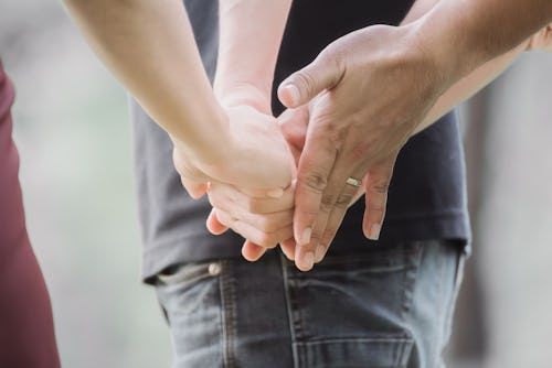 Love triangle. Young woman in relationship with two men.back view of threesome love friends of two m...