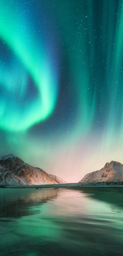 Aurora borealis in Lofoten islands, Norway. Aurora. Green northern lights. Starry sky with polar lig...
