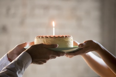 Close up of worker congratulate colleague with birthday, presenting baked cake with lit candle, empl...