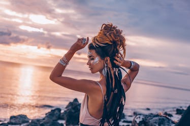 cheerful smiling young woman in elegant dress on the beach at sunset close up portrait