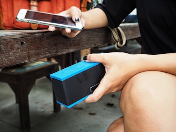 Woman using bluetooth speaker with smart phone
