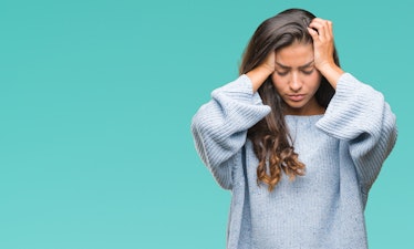 Young beautiful arab woman wearing winter sweater over isolated background suffering from headache d...