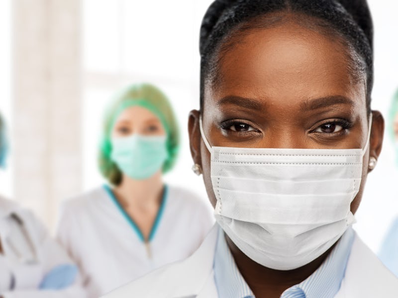 health, medicine and pandemic concept - close up of african american female doctor or scientist in p...