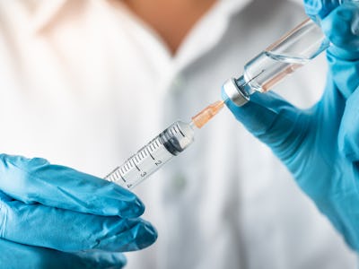 Doctor, nurse, scientist, researcher hand in blue gloves holding flu, measles, coronavirus, covid-19...