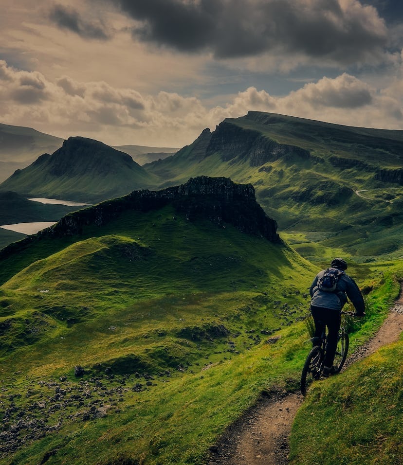 Mountain biker riding through rough mountain landscape of Quiraing, Isle of Skye, Scotland, UK