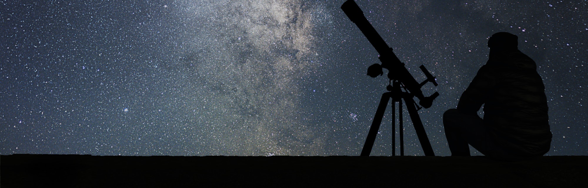 Man with astronomy  telescope looking at the stars. Man telescope and starry sky. Night sky. Milky w...