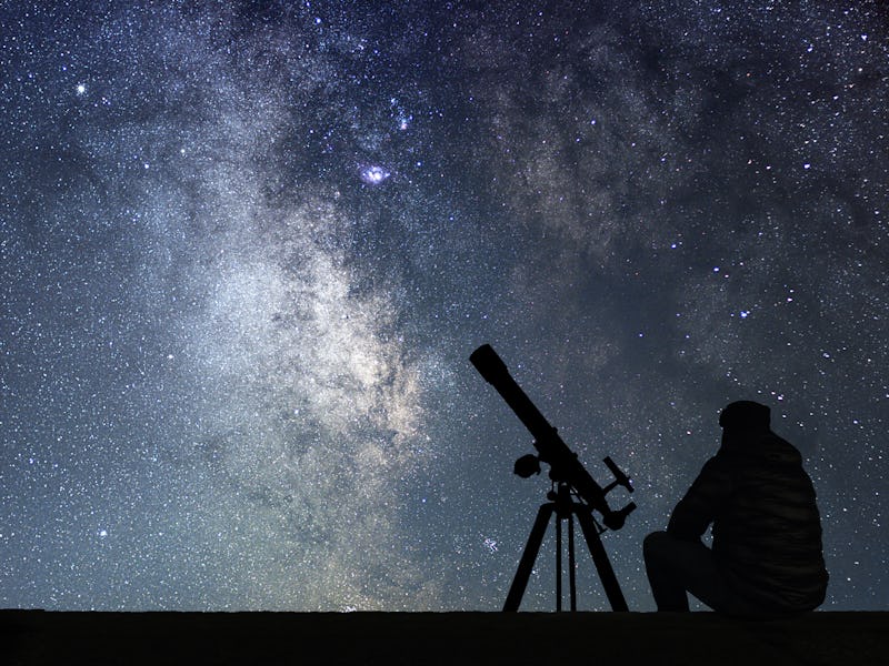 Man with astronomy  telescope looking at the stars. Man telescope and starry sky. Night sky. Milky w...