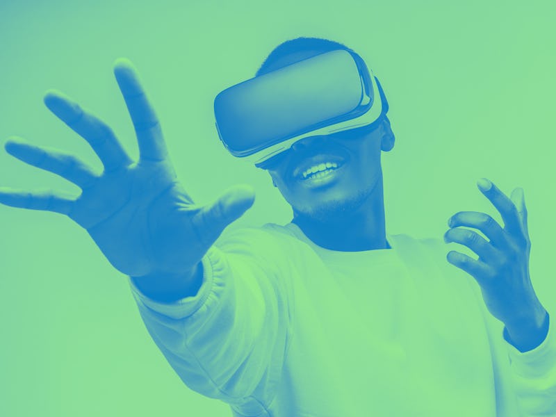 African american man in vr glasses, playing video games with virtual reality headset, trying to touc...