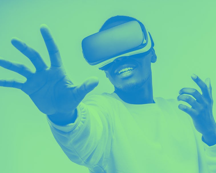 African american man in vr glasses, playing video games with virtual reality headset, trying to touc...