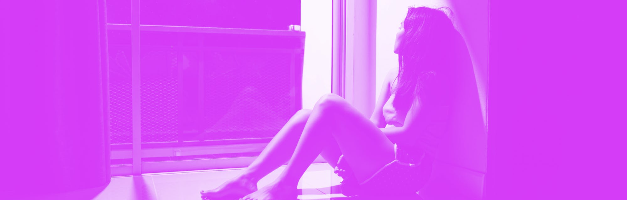 Sad and depressed young woman sitting on the floor in the living room looking outside the doors,sad ...