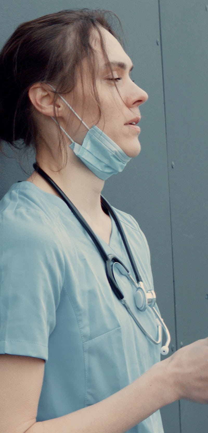 Portrait of tired exhausted nurse or doctor having a coffee break outside in the morning. COVID-19, ...