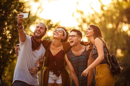 Group of friends taking selfie on their way to festival