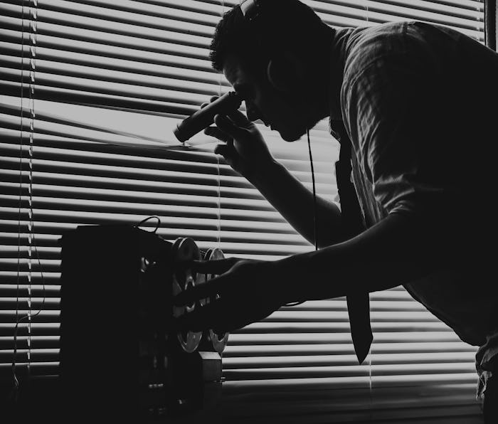 A man wearing a tie can be seen spying through the window. He seems to be a special agent listening ...