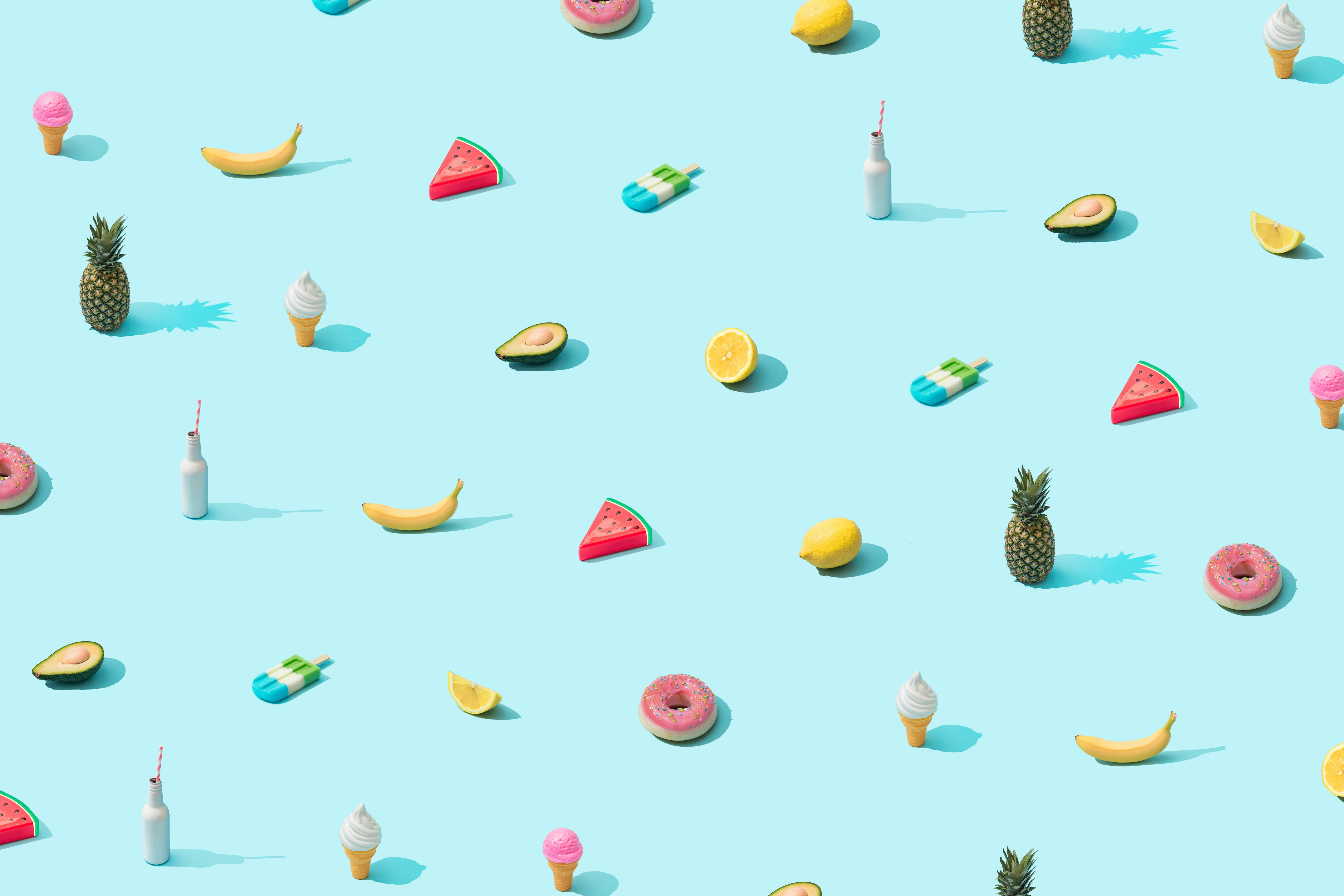 Trendy sunlight Summer pattern made with various summer food on bright light blue background. Minima...