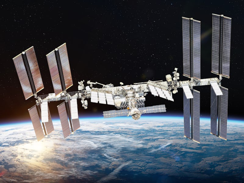 International space station on orbit of Earth planet. ISS. Dark background. Sun reflection. Elements...